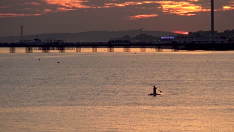 Sonnenuntergang-Silhouette-Von-Brighton-Pier-Und-Mann-Auf-Dem-Paddelbrett