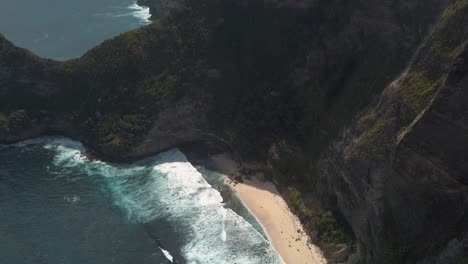 Aerial-view-of-the-tourist-hotspot-Kelingking-beach-on-Nusa-Penida,-Indonesia-on-a-sunny-day-and-with-crystal-blue-water