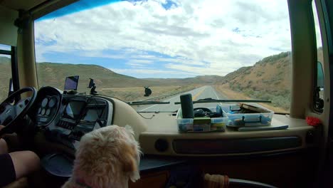 POV-of-the-passenger-in-a-large-class-A-Recreational-Vehicle-while-driving-through-the-Okanogan-Highlands-of-north-central-Washington-State-with-a-labradoodle-dog-in-the-foreground
