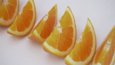 Beweglicher-Schuss-Von-Orangenscheiben-Keilen-Auf-Weißem,-Isoliertem-Hintergrund,-Gesunde-Lebensmittelauswahl