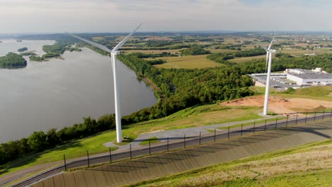 Aerial-of-beautiful-Lancaster-County-PA-farmland-with-wind-turbines-high-above-Susquehanna-River,-view-of-ice-cream-manufacturing-plant