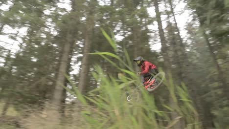 Mountain-bike-rider-jumping-sideways-over-a-large-jump-in-the-bike-park