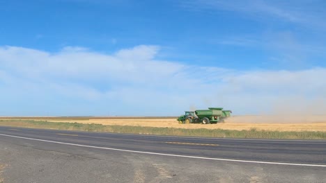 Mähdrescher-Und-Getreidewagen-Ernten-Weizen-Im-östlichen-Bundesstaat-Washington,-Wobei-Der-Verkehr-Im-Vordergrund-Vorbeifährt