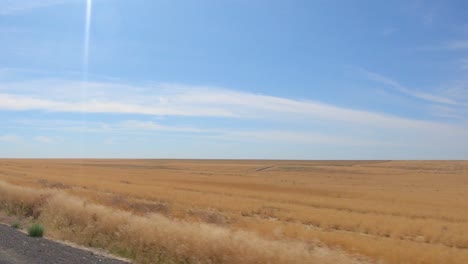 POV-out-the-passenger's-window-while-driving-past-recently-harvested-wheat-field-in-agricultural-area-of-the-Okanogan-Highlands-of-north-central-Washington-State