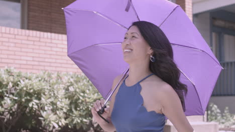 Asian-woman-walks-down-the-street-with-a-purple-umbrella-on-a-sunny-day