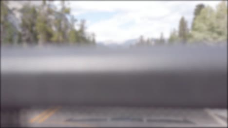 Verschwommene-Sicht-Der-Fokussiertechnik-Aus-Dem-Fahrenden-Auto-Während-Der-Fahrt-Auf-Dem-Lokalen-Naturweg-In-Kanada-Mit-Natürlichem-Blick-Auf-Die-Bergkette-Und-Den-Pinienwald-In-Den-Sommerferien