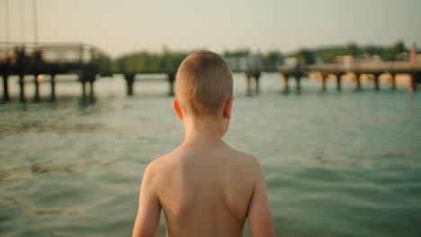 The-boy-enters-the-lake,-close-up-–-slow-motion