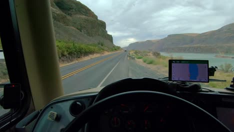 POV-of-the-driver-of-a-parked-Class-A-RV,-point-of-view-of-Lenore-Lake-and-Highway-17-in-Washington-State-on-a-cloudy,-windy-day