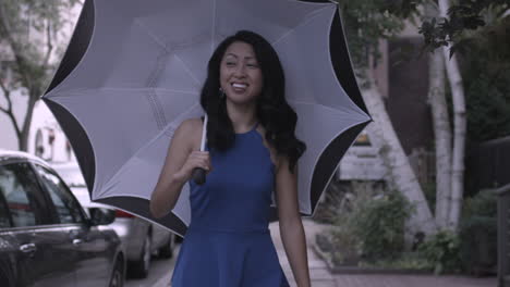 Stabilized-shot-of-an-Asian-woman-walking-down-the-street-with-a-black-and-white-umbrella