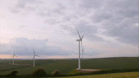 Landschaftsansicht-Von-Windturbinen,-Die-Grüne-Energie-Gegen-Schönen-Abendhimmel-Produzieren,-Schwenkschuss