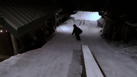 male-snowboarder-on-rail-in-a-park-built-in-his-backyard-at-night
