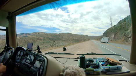 POV-of-the-passenger-in-a-large-class-A-Recreational-Vehicle-while-merging-back-on-to-the-highway-the-Okanogan-Highlands-of-north-central-Washington-State-with-a-labradoodle-dog-in-the-foreground