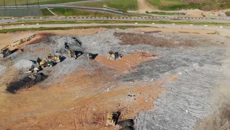 Aerial-view-of-landfill,-trucks-and-equipment-at-dump,-vultures-and-scavengers-flying-at-waste-and-dump