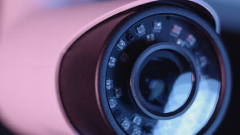 Tight-orbiting-macro-shot-of-a-security-camera-with-bokeh-reflected-in-the-lens