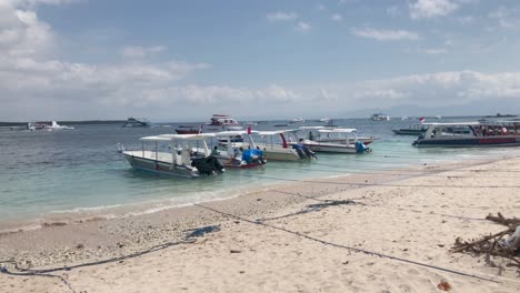 Pequeños-Botes-En-Una-Playa-De-Arena-Con-Aguas-Cristalinas-En-Bali,-Indonesia