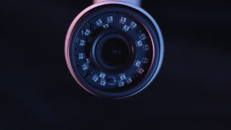 Still-shot-of-the-front-of-a-security-camera-against-a-black-background