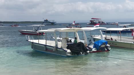 Kleine-Boote-An-Einem-Sandstrand-Mit-Kristallklarem-Wasser-In-Bali,-Indonesien