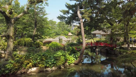 Japanese-Garden-Shukkei-en-in-Hiroshima,-with-a-pond-and-a-red-bridge-in-may