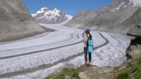 A-lone-female-hiker-looks-toward-a-vast-glacier