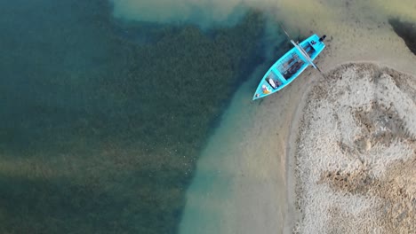 Wooden-traditional-small-boat-tied-near-sandy-banks-aerial-view
