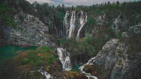 4k-UHD-Cinemagraph-of-fresh-blue-water-flowing-down-beautiful-waterfalls-between-a-wooden-foot-bridge-in-the-famous-Plitvice-National-Park-in-Croatia,-where-the-classic-Winnetou-movies-were-filmed