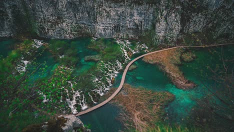 4k-UHD-Cinemagraph-of-fresh-blue-water-flowing-down-beautiful-waterfalls-between-a-wooden-foot-bridge-in-the-famous-Plitvice-National-Park-in-Croatia,-where-the-classic-Winnetou-movies-were-filmed