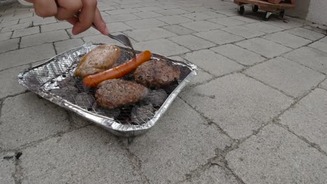 Time-lapse-of-disposable-mini-BBQ-grill-with-burgers,-sausages-and-meat