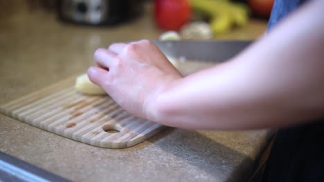 Slow-motion-shot-of-someone-using-a-knife-to-cut-a-ripe-yellow-banana-into-small-slices