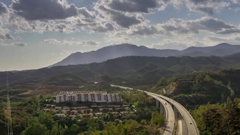 Zeitraffer-Der-Berge-Von-Marbella-Mit-Sich-Bewegenden-Wolken-Und-Einer-Autobahn,-Die-In-Die-Ferne-Führt,-Landschaftsszene