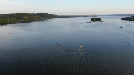 Friedlich-Aufsteigende-Luftdrohnenaufnahme-Von-Booten-Und-Ihrem-Kielwasser-Auf-Dem-Blauen-Susquehanna-Fluss-Bei-Sonnenuntergang