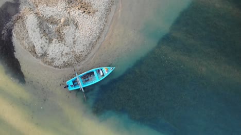 Wooden-traditional-small-boat-tied-near-sandy-banks-aerial-view