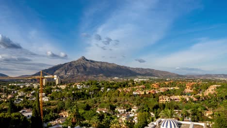 4k-time-lapse-of-sunny-day-view-of-la-concha-mountain-in-marbella-houses-in-foreground,-blue-sky-with-beautiful-moving-clouds-summer-vacation-location-costa-del-sol,-malaga,-spain