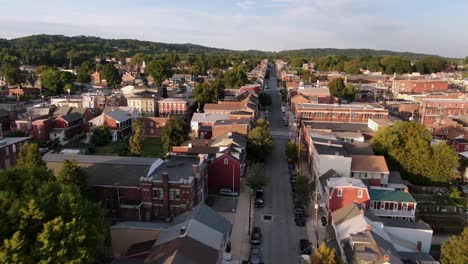 Cinematic-drone-aerial-tracking-street-in-small-town-America-neighborhood-community-at-sunset