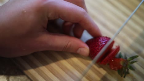 Zeitlupenaufnahme-Von-Jemandem,-Der-Mit-Einem-Scharfen-Messer-Rote,-Frische-Erdbeeren-In-Scheiben-Schneidet