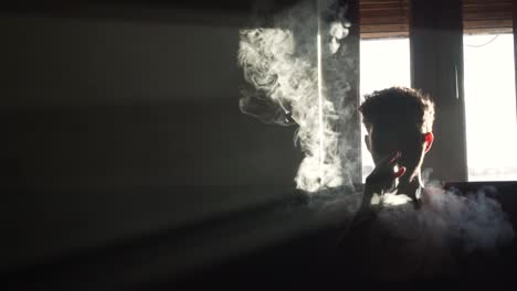 Silhouette-of-a-man-vaping-in-the-dark-with-smoke-flowing-in-slow-motion
