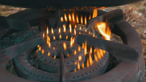 Calentador-De-Gas-Oxidado-Ardiendo-Con-Llamas-Amarillas-Bajo-Un-Caldero-Negro