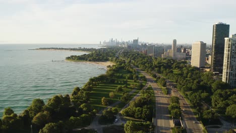 Aerial-pullback-of-cars-traveling-along-Lake-Shore-Drive-with-Chicago-skyline-in-background