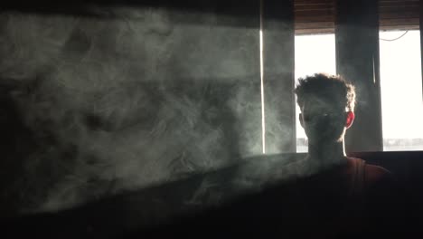 Man-surrounded-by-smoke-in-slow-motion-in-dark
