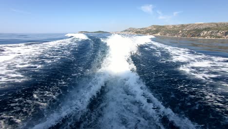 Wasserkamm-Hinter-Einem-Schnellen-Boot,-Das-An-Einem-Sommertag-über-Blaues-Meerwasser-Rast