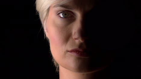 Close-up-of-woman-face-on-dark-background