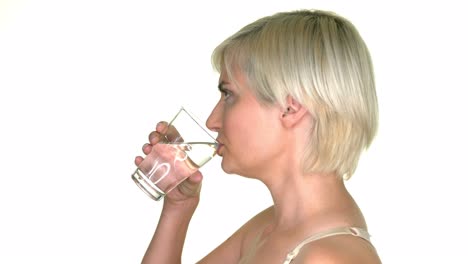 Side-view-of-woman-drinking-water,-standing-on-white-background
