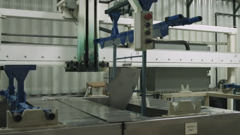 Slider-shot-of-machine-lowering-metal-parts-into-a-chemical-bath-for-treatment-in-a-manufacturing-facility