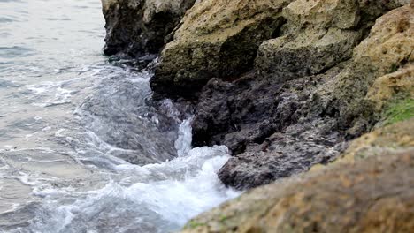 Calm-waves-hiting-rocks-on-a-gloomy-day-in-slow-motion