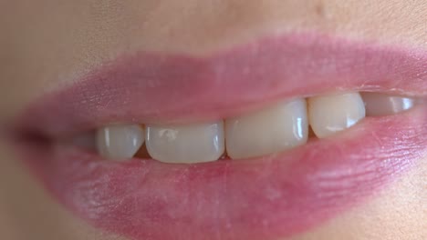 Extreme-closeup-on-a-lips-of-a-young-adult-woman-with-a-perfect-white-healthy-smile
