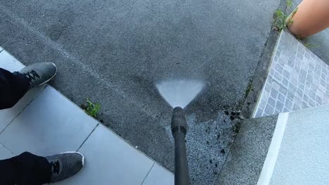 Home-entrance-and-driveway-cleaning-with-high-pressure-water-jet-cleaner,-slow-motion