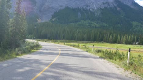 Schöne-Landschaftsansicht-Der-Lokalen-Straße-Unter-Dem-Natürlichen-Schönen-Nationalpark-In-Banff,-Kanada-Mit-Rockie-Bergen-Und-Kiefernwald-Im-Hintergrund-Im-Sommer-Tagsüber,-Alberta,-Kanada