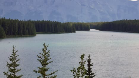 Paisaje-Hermosa-Vista-Natural-Del-Lago-Two-Jack-Con-Un-Hermoso-Bosque-De-Pinos-Y-Montañas-Rocosas-En-El-Fondo-En-El-Parque-Nacional-De-Banff,-Alberta,-Canadá-En-Verano-Sol-Durante-El-Día