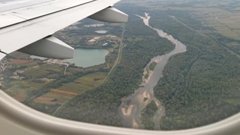 Flyover-river,-lake-and-fields-footage-from-passenger-cabin