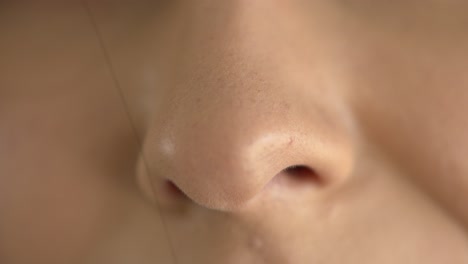Extreme-macro-close-up-of-a-woman's-nose-while-breathing-in-fresh-air