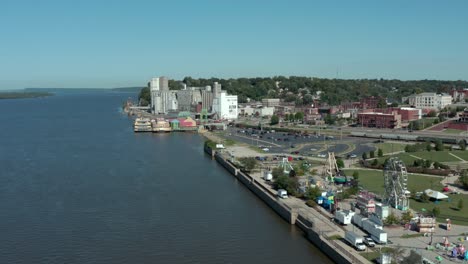 Drone-footage-of-the-Mississippi-River-at-Alton,-Illinois,-the-riverfront,-a-carnival,-downtown-buildings,-and-harbor